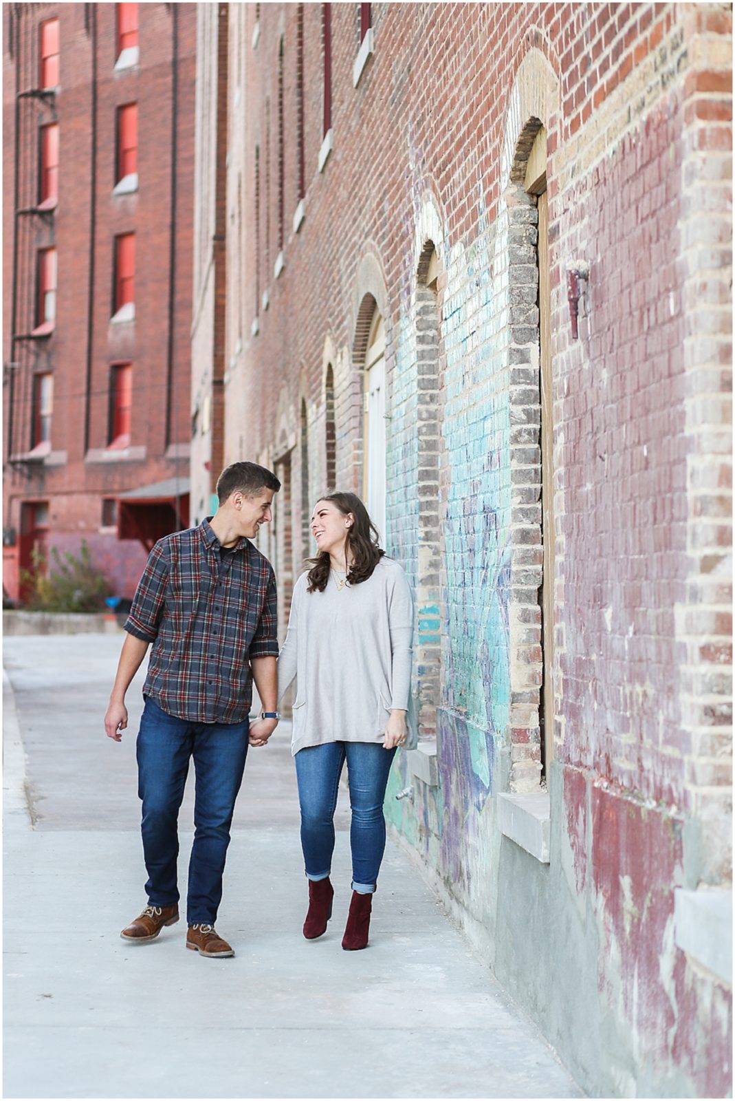 couple walking in west bottoms - Avery and Jack Engagement Session - Kansas City West Bottoms Engagement Portraits - KC Wedding Photographer - Olathe Lenexa Leawood Kansas Wedding Photography and Video  - Mariam Saifan Photography 