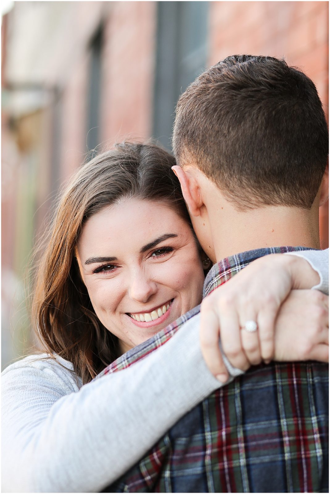 bride hugging groom - Avery and Jack Engagement Session - Kansas City West Bottoms Engagement Portraits - KC Wedding Photographer - Olathe Lenexa Leawood Kansas Wedding Photography and Video  - Mariam Saifan Photography 