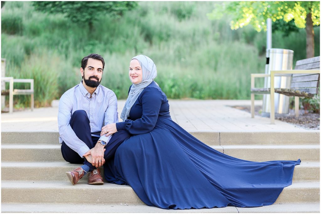 couple poses sitting on steps outdoor - Kauffman Center of Performing Arts Anniversary Session | Kansas City Crossroads Portraits and Engagement Session | Best Kansas City Portrait and Wedding Photographer | Wedding Photography by Mariam Saifan Photography | Wedding and Engagement Photo Locations in the Kansas City Area