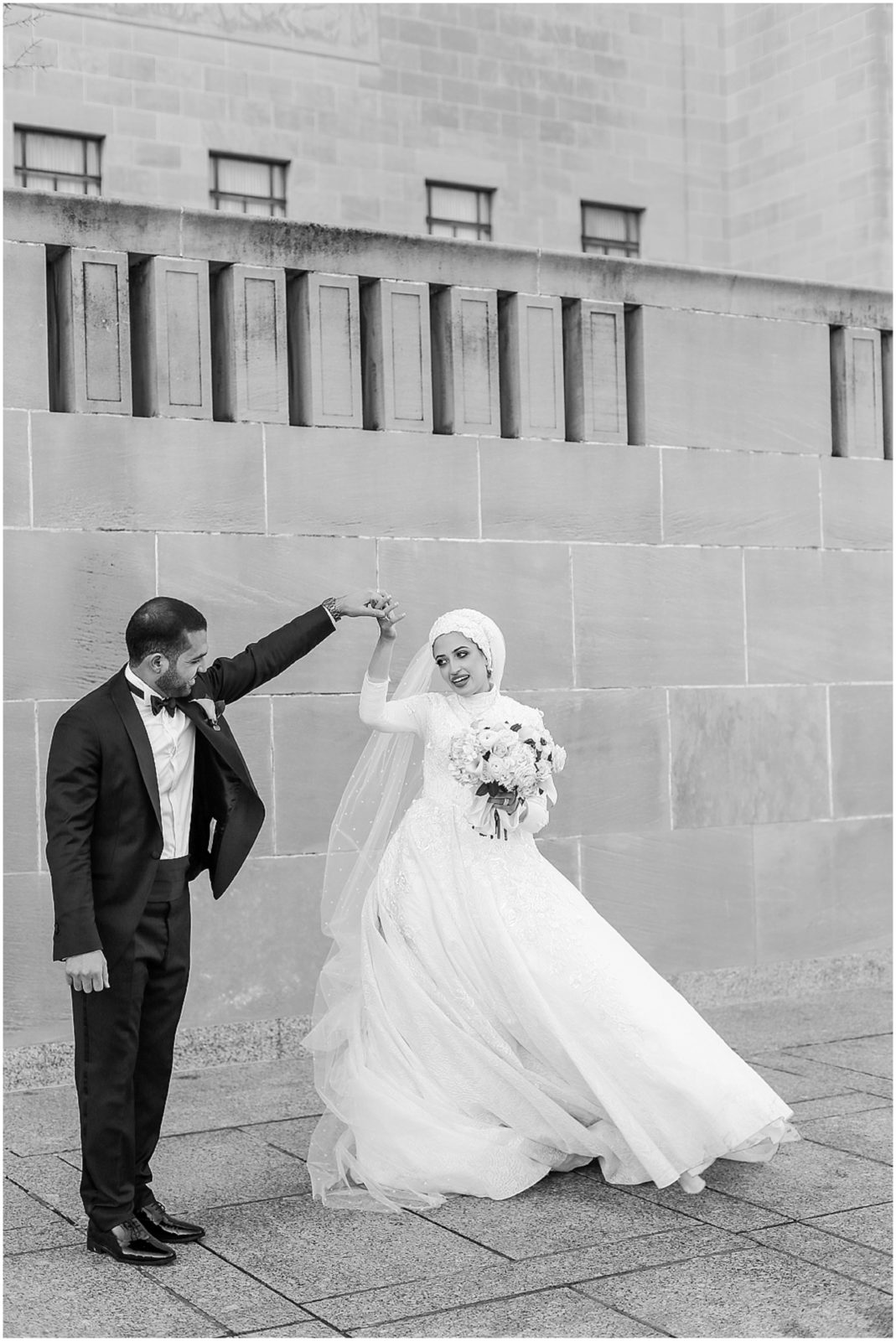 bride and groom laughing with their wedding portraits 