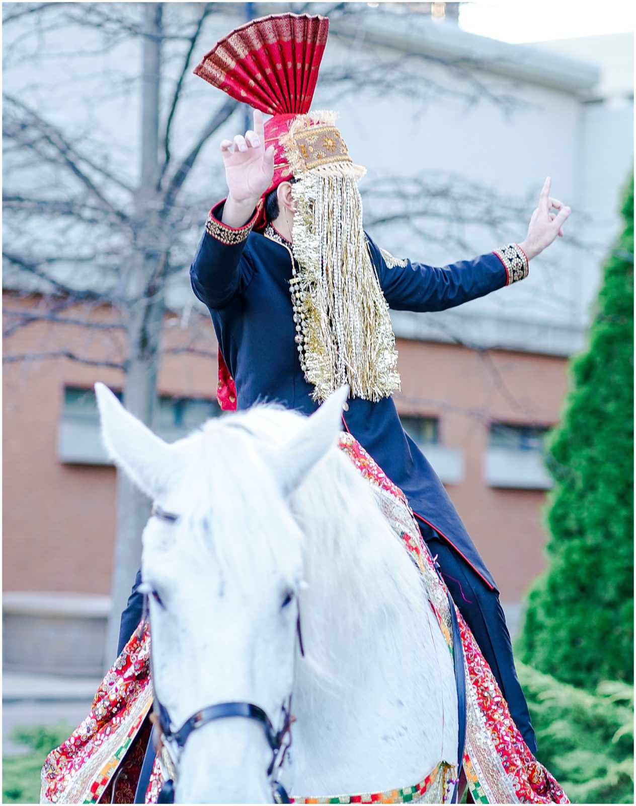 happy groom making entrance into his wedding on a horse - baraat - st louis four seasons 