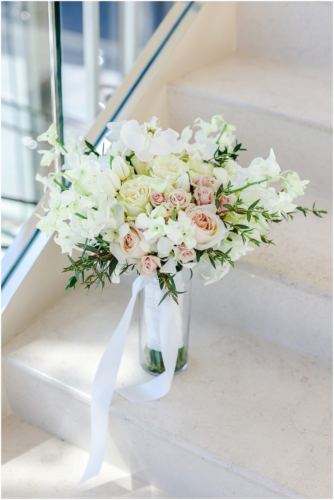 beautiful white wedding flowers photographed on the stairs at the four seasons wedding stl 