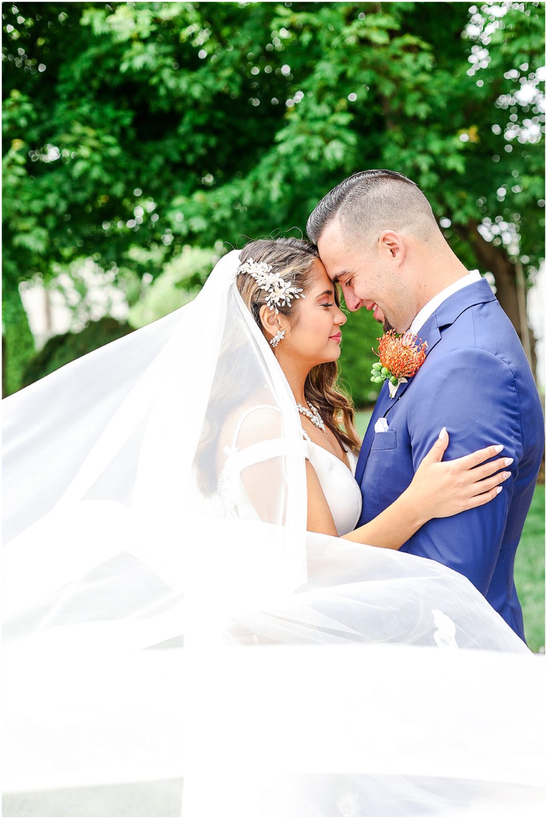 Gorgeous Bride & Groom Wedding Photos taken at the Kansas City Wedding Venue - Rhapsody - by Mariam Saifan Photography - Long Wedding Veil - Lace Wedding Dress - Tropical Wedding Theme