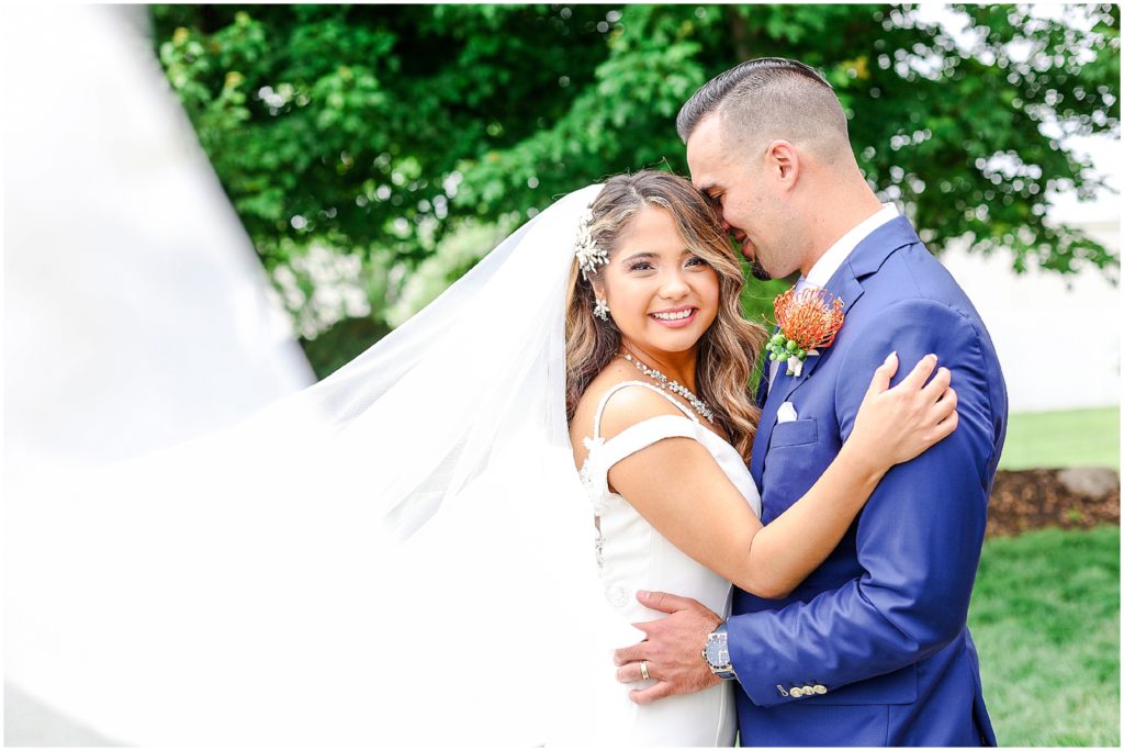 Gorgeous Bride & Groom Wedding Photos taken at the Kansas City Wedding Venue - Rhapsody - by Mariam Saifan Photography - Long Wedding Veil - Lace Wedding Dress - Tropical Wedding Theme