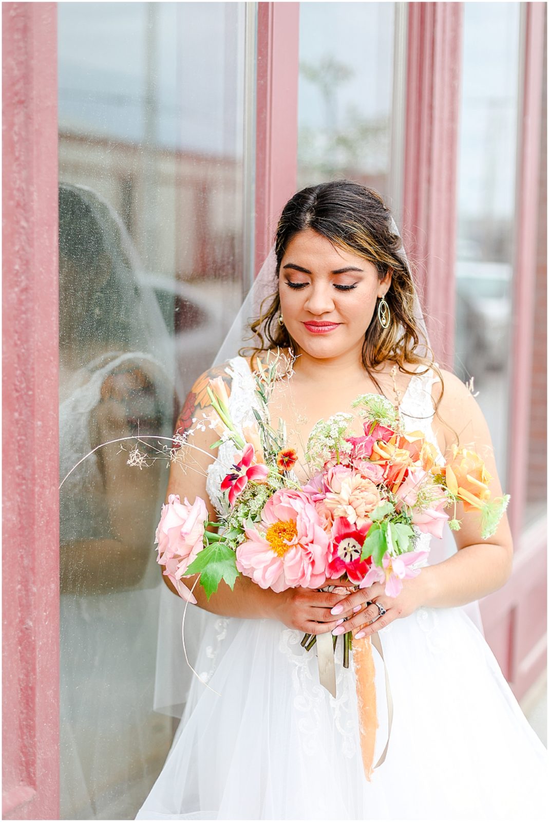 beautiful bride looking at her wedding bouquet at kansas city feasts of fancy