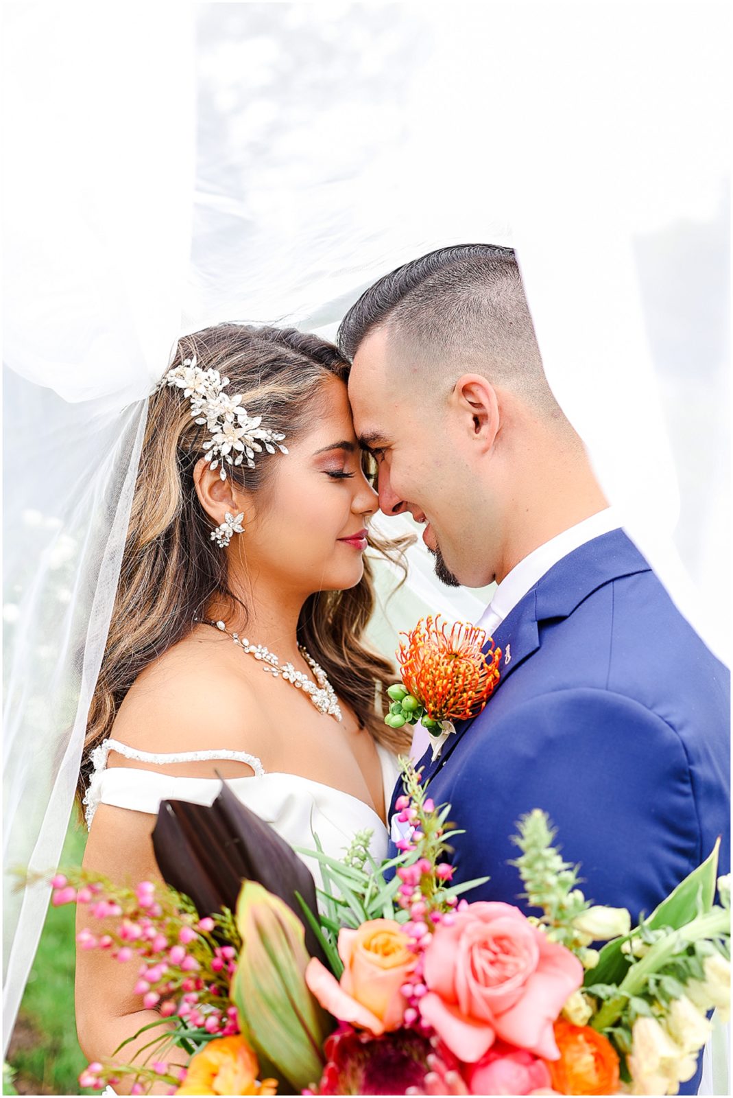 bride & groom under wedding veil 