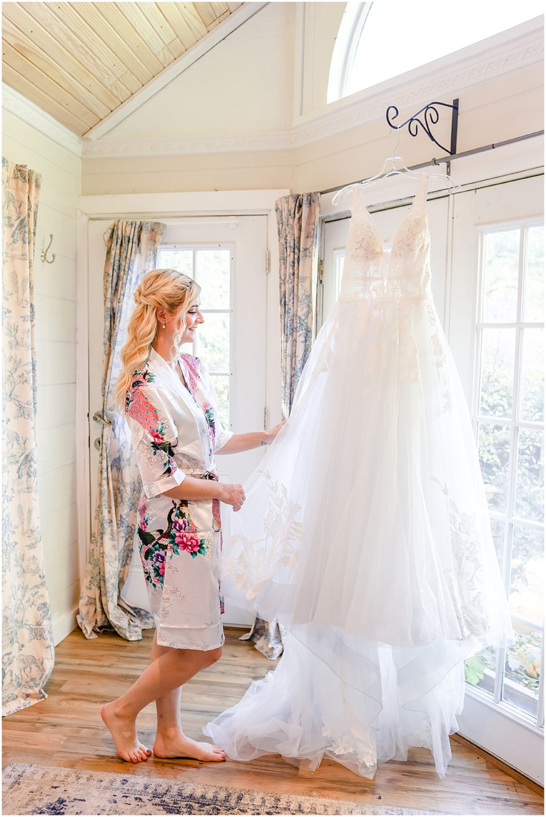 bride looking at her lace wedding dress at the secret garden 