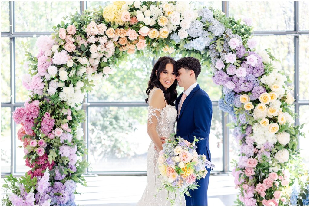 white lace wedding dress with long veil by the One Bridal in kansas city - Mariam Saifan Photography - luxury wedding photography based in KC and STL 30A Florida - Colorful pink flower arch for wedding - italian wedding theme - garden wedding theme  - avent orangery - hair by ezoza 